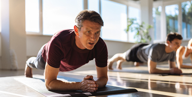 Adultos en posición de plancha, ejercitando su cuerpo