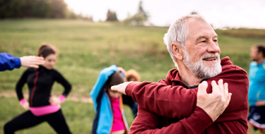 Adulto mayor estirando sus músculos al aire libre