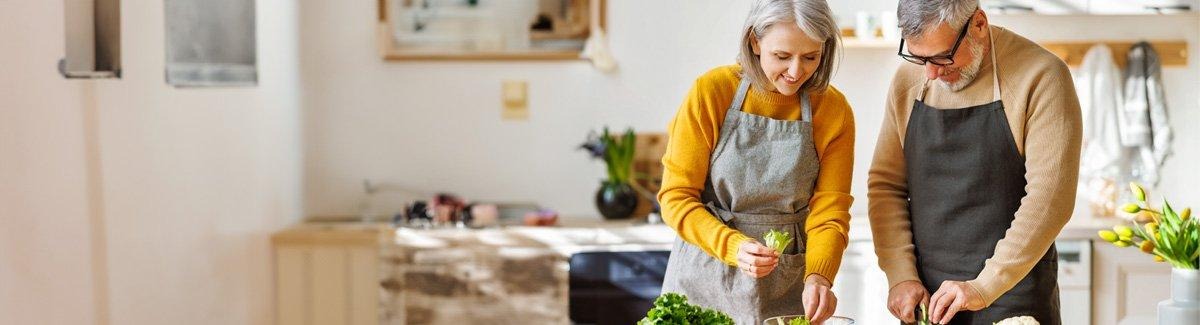 Pareja de adultos preparando comida saludable