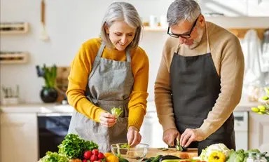 Pareja de adultos preparando comida saludable