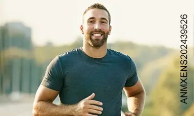 hombre trotando al aire libre, sonriendo en un día soleado