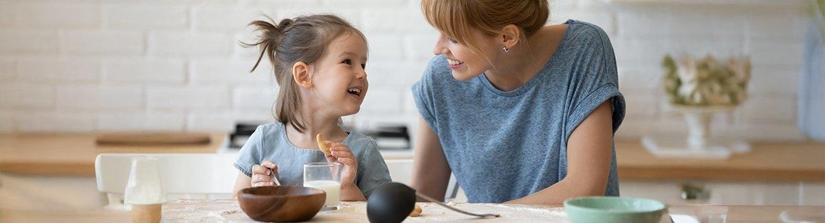 Niña comiendo mientras el sonrie a su mamá