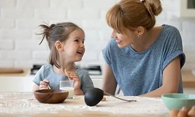 Niña comiendo mientras el sonrie a su mamá