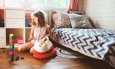 Niña jugando con casas de juguete