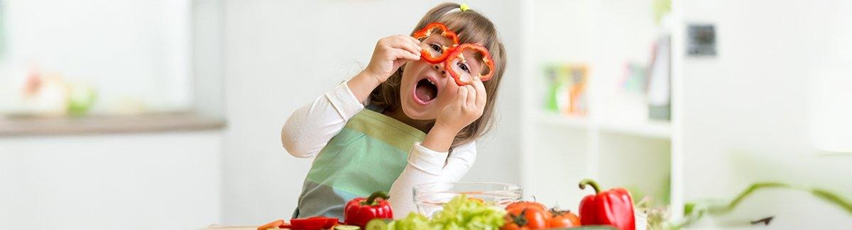 Niño con el rostro borroso, vistiendo un delantal y aparentemente preparando comida en un entorno de cocina.
