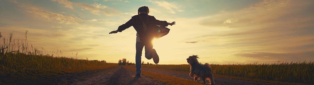 Niño corriendo junto a un perro