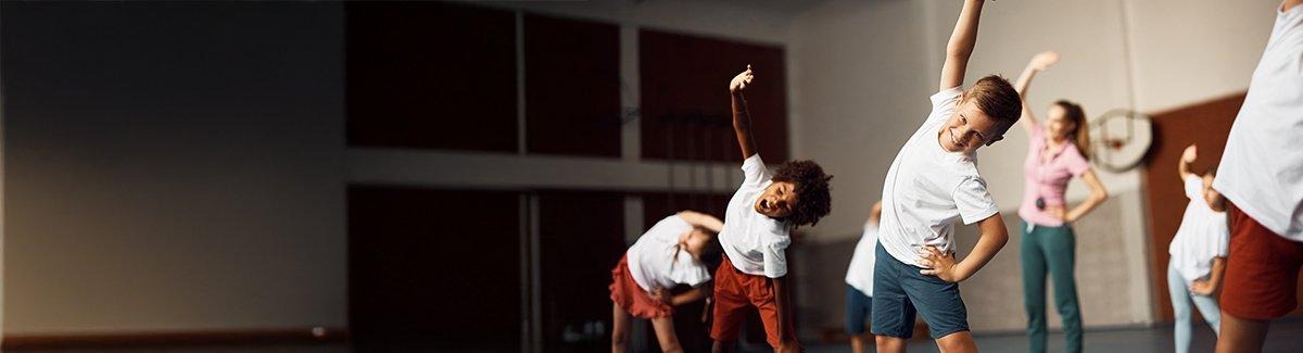 Niños estirando su cuerpo