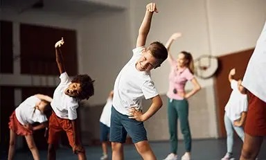 Niños estirando su cuerpo
