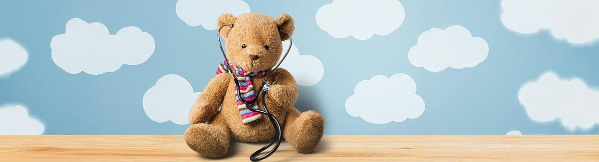 Osito de peluche sosteniendo un estetoscopio, posicionado en el lado derecho de la imagen. El lado izquierdo presenta un fondo púrpura con una estrella amarilla en la parte superior.