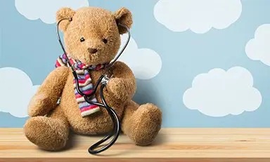 Osito de peluche sosteniendo un estetoscopio, posicionado en el lado derecho de la imagen. El lado izquierdo presenta un fondo púrpura con una estrella amarilla en la parte superior.