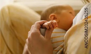 mamá amamanta a su bebé mientras sostiene su mano tiernamente