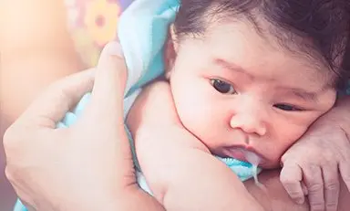 Mamá sacando gases a su hija