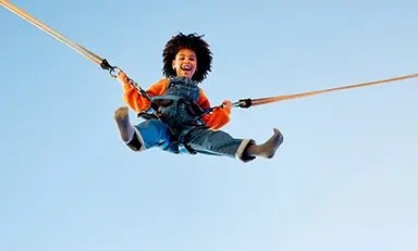 Niño saltando en trampolin con equipo de seguridad