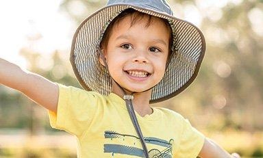 Niño sonriente con los brazos abiertos en la naturaleza