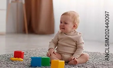 Bebe sentado en un tapete llorando