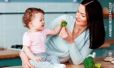 mamá dándole de comer a su hija pequeña alimentos saludables