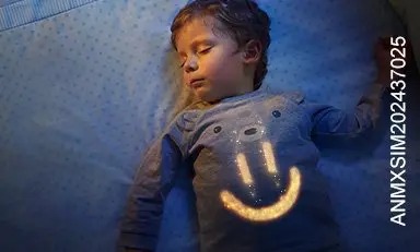 Niño dormido plácidamente en su cama con una carita sonriente dibujada en su pecho